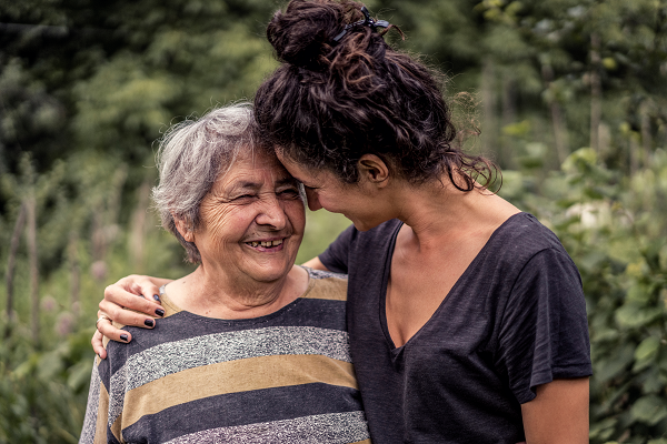 Young person with arm around an elderly person