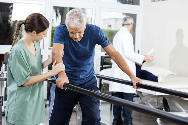 Man being helped with his mobility by an Occupational Therapist