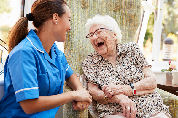 Carer and elderly lady chatting and laughing
