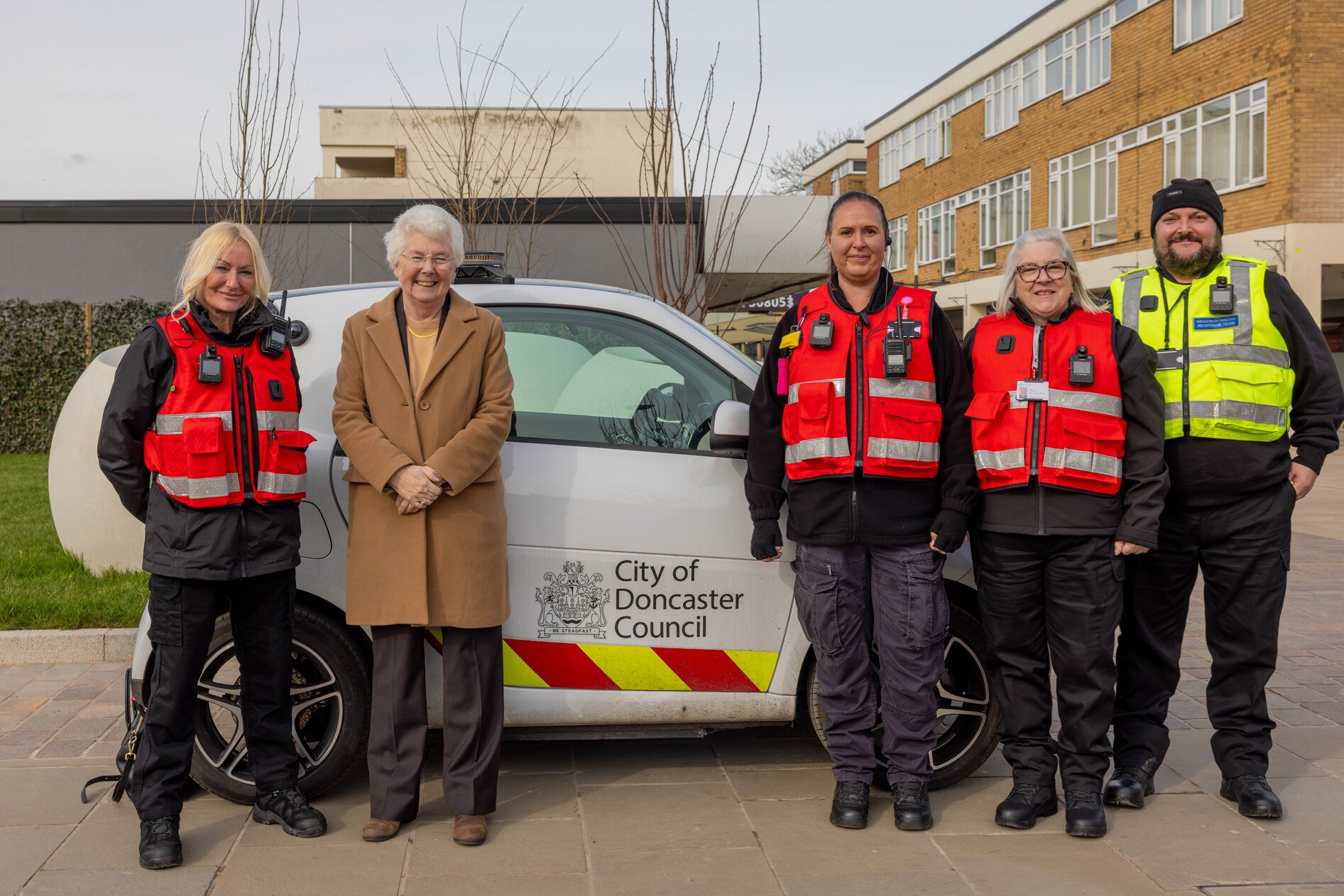 Mayor stood next to electric vehicle and new engagement officers 