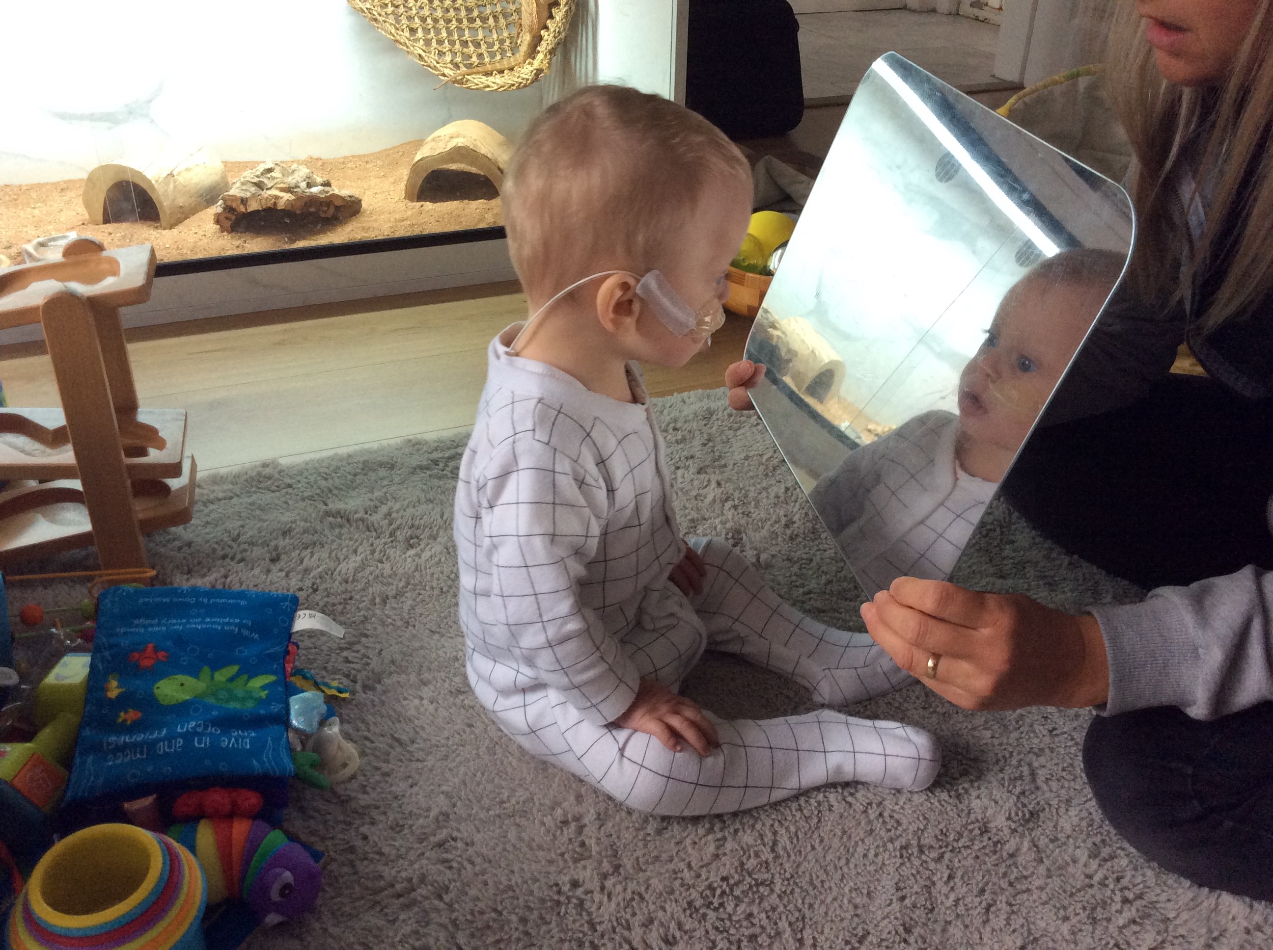 Toddler looking in mirror at themselves