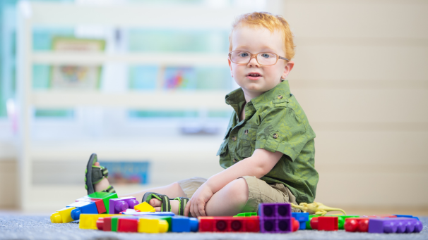 Child sat on floor playing with blocks