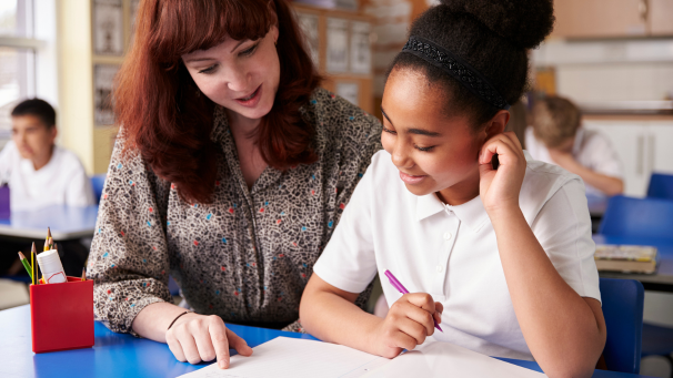 Image showing a teacher supporting child in classroom